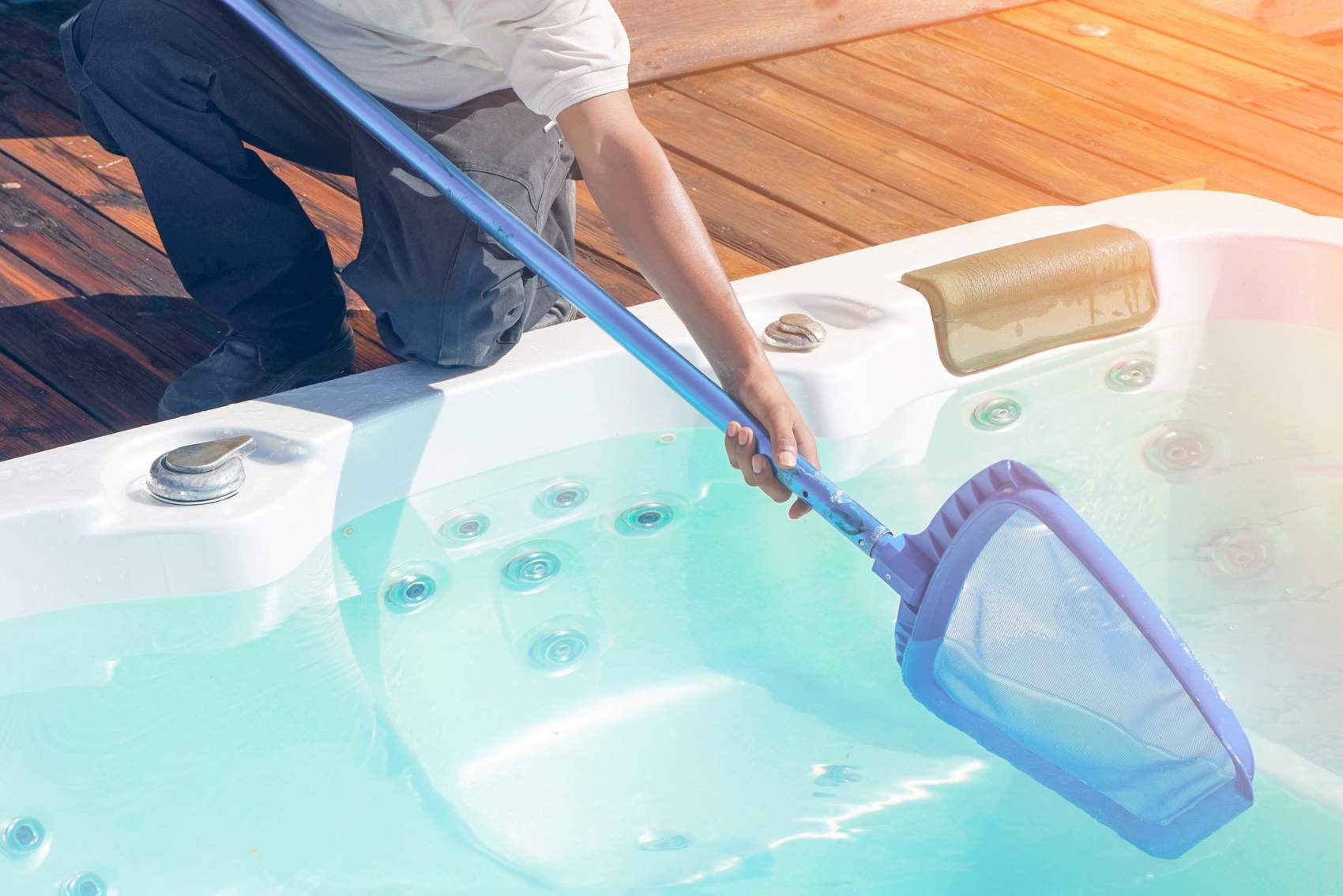 Pool cleaner during his work. African hotel staff worker cleaning the jacuzzi.