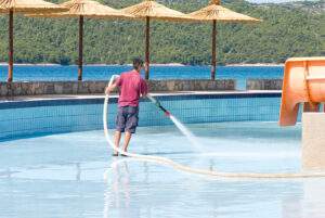 a man washing swimming pool